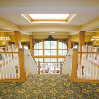 A beautifully designed staircase leading to a well-lit lobby with elegant decor.