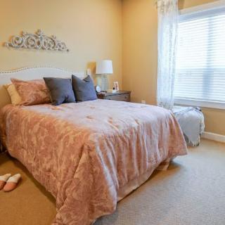 A cozy bedroom with a neatly made bed and soft lighting.