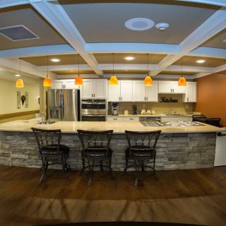 A modern kitchen with a spacious island, featuring stainless steel appliances and stylish pendant lighting.