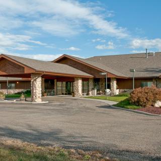 A modern suburban building with stone and wood elements under a clear blue sky.