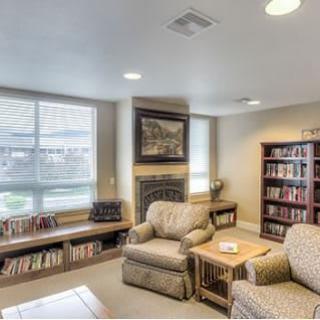 A cozy living room with bookshelves and comfortable seating.