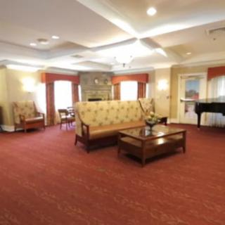A spacious living room with comfortable seating, a coffee table, and a piano.
