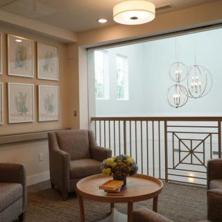A cozy waiting area with comfortable chairs, a central coffee table, and elegant wall decor.