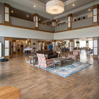 A spacious and elegantly designed lobby featuring modern furniture and a large chandelier.