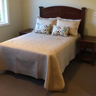 A neatly made bed with decorative pillows and wooden side tables in a cozy bedroom.