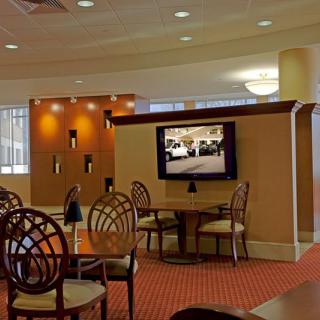 A modern hotel lobby with a seating area and television.