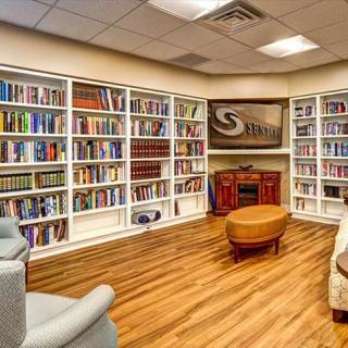 A cozy library with well-organized bookshelves and comfortable seating.