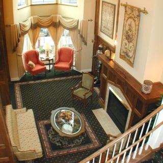 A cozy living room with a fireplace, elegant seating, and classic decor viewed from an upper level.