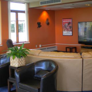 A cozy lounge area with comfortable seating, a television, and decorative elements.
