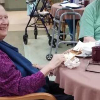 Elderly individuals enjoying a meal and conversation.