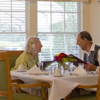 An elderly couple enjoying a meal together at a restaurant.