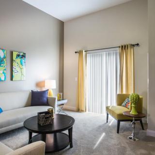 A modern living room with stylish decor, featuring a comfortable sofa, coffee table, and vibrant artwork.