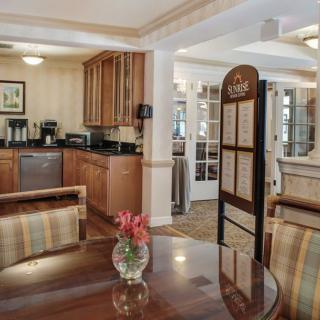 A cozy kitchen and dining area with wooden cabinets and a table decorated with flowers.