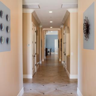 A well-lit hallway with artistic wall decor and multiple doors.