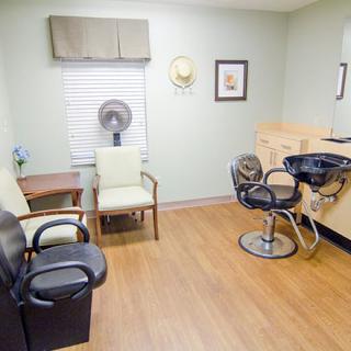 An interior view of a hair salon with multiple chairs and a hair styling station.