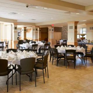 A spacious banquet hall with neatly arranged tables and chairs, ready for an event.