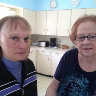 Two individuals standing in a kitchen setting.