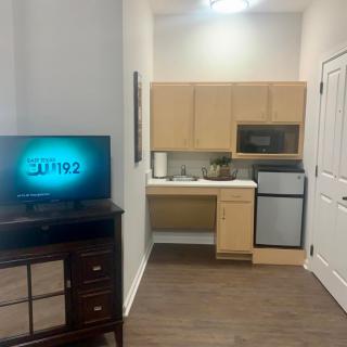 Compact apartment kitchen with a TV and basic appliances.