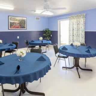 A well-decorated dining area featuring blue tablecloths and a bright, inviting atmosphere.