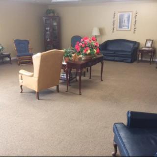 A spacious living room with furniture and floral decorations.