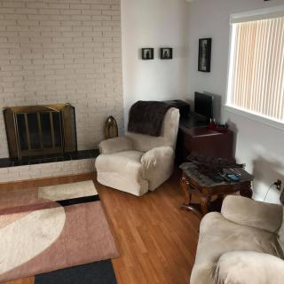 A cozy living room with a fireplace and armchairs.