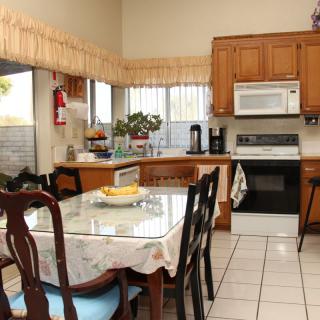A cozy kitchen with wooden cabinets, a dining table, and household appliances.