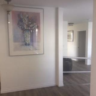 A modern hallway featuring framed artwork and a large mirror.