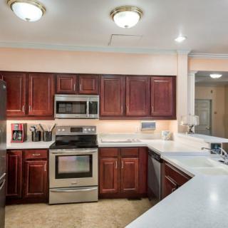 A modern kitchen with stainless steel appliances and wooden cabinetry.