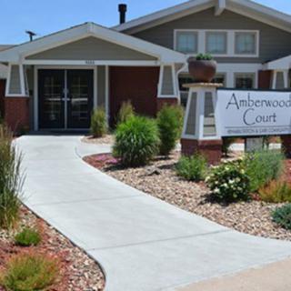 An inviting entrance to a residential building with well-maintained landscaping and a clear pathway.
