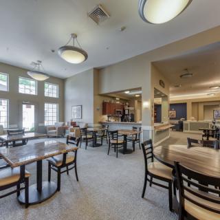 A spacious cafe interior with modern furnishings and ample natural light.