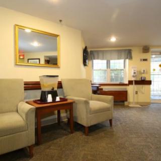 A cozy waiting room with comfortable chairs, a small table, and ambient lighting.