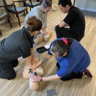 Participants engage in CPR training, practicing lifesaving techniques on a training dummy.