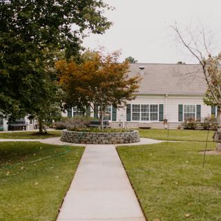 A suburban house with a neatly landscaped lawn and sidewalk.
