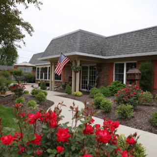 A welcoming house with a beautiful garden and an American flag.
