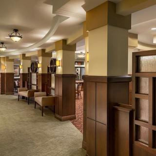 A modern hotel lobby with wood paneling and comfortable seating areas.