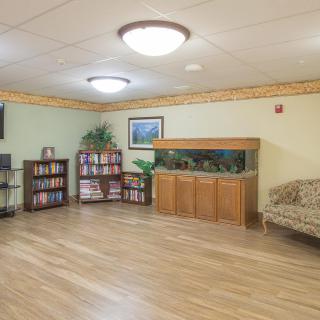 A cozy living room with an aquarium, bookshelves, and a comfortable sofa.