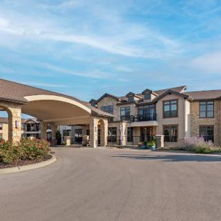 A welcoming hotel entrance with a modern architectural design under a clear blue sky.