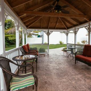 A cozy gazebo with outdoor seating and garden views.