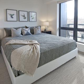 A modern and minimalist bedroom with a large bed, stylish decor, and ample natural light from the window.