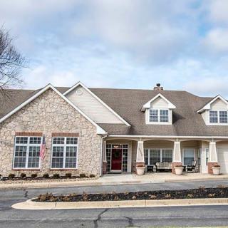 A suburban house with a stone facade and gabled roof.