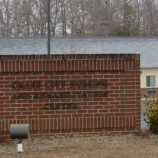 A brick sign in front of a building with surrounding trees.