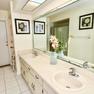 A modern bathroom featuring a double sink with a large mirror and elegant decor.