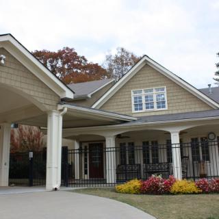 A charming residential house with autumn foliage and a landscaped front yard.