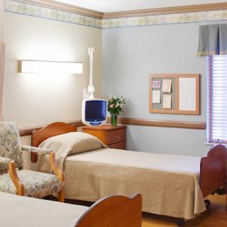 A hospital room with two beds and basic furnishings.