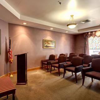 A small meeting room with a podium and arranged chairs.