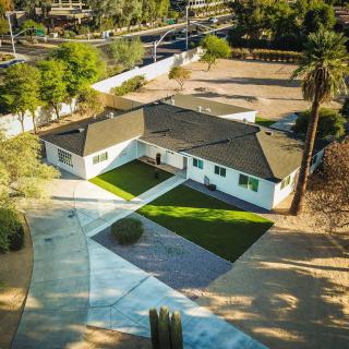 Aerial view of a suburban house with a spacious yard and driveway.