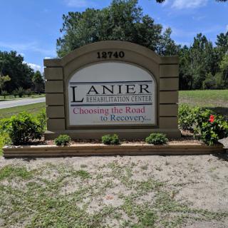 Welcome sign for Lanier Community, featuring landscaping and a clear blue sky.
