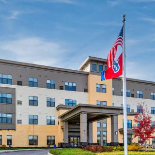 A modern healthcare facility with flags displayed at the entrance.