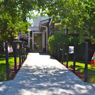 A serene pathway leading to an entrance surrounded by greenery.
