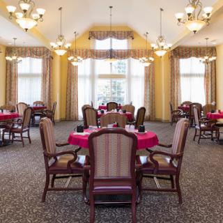 A well-lit dining room featuring elegantly set tables and comfortable seating.